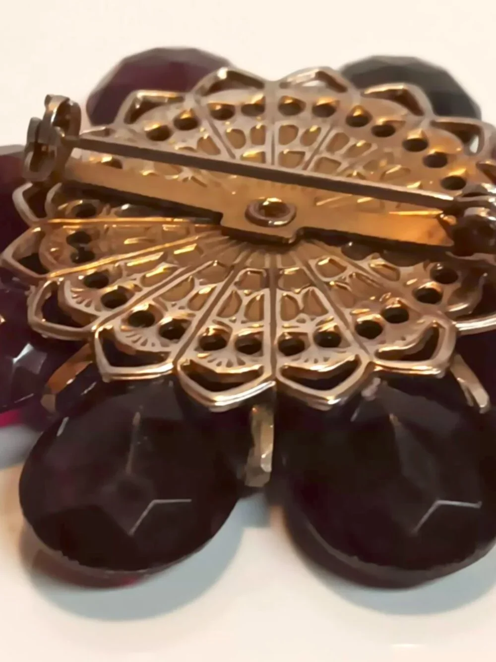 Vintage ruby lucite brooch with aurora borealis central rhinestone.